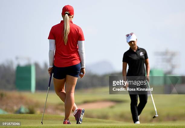 Charley Hull of Great Britain watches Lydia Ko of New Zealand on the 18th green during the second round of the Women's Individual Stroke Play golf on...