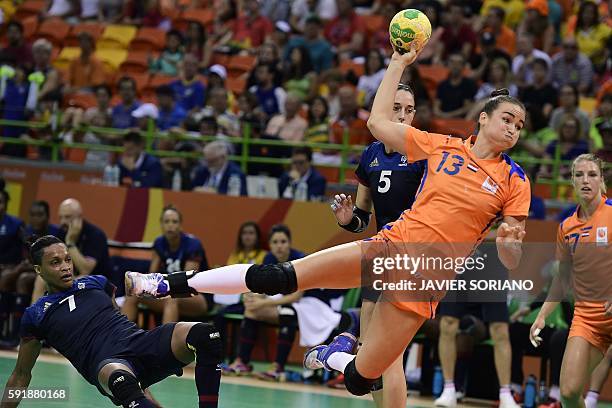 Netherlands' pivot Yvette Broch (R0 jumps to shoot past France's left back Allison Pineau during the women's semifinal handball match Netherlands vs...