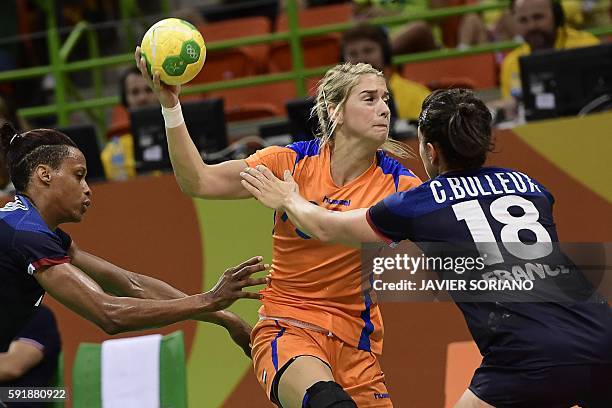 Netherlands' left back Estavana Polman vies with France's left back Allison Pineau and France's right wing Chloe Bulleux during the women's semifinal...