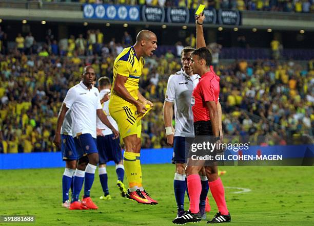 Maccabi's forward Tal Ben Haim reacts as he receives a yellow card from Spanish referee Jesus Gil Manzano during the qualifying football match of the...