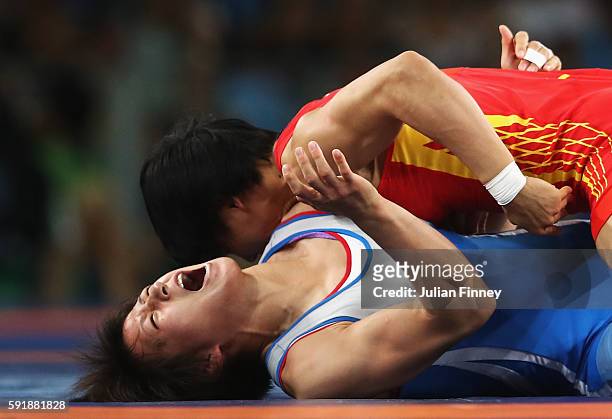Myong Suk Jong of Republic of Korea competes against Xuechun Zhong of China during the Women's Freestyle 53 kg Repechage Round 2 match on Day 13 of...