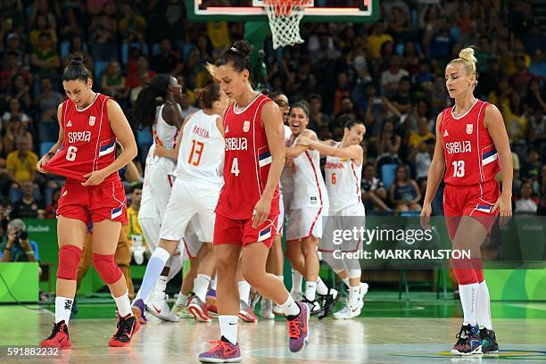 Serbia's shooting guard Sasa Cado, Serbia's point guard Tamara Radocaj and Serbia's point guard Milica Dabovic leave the court after losing to Spain...