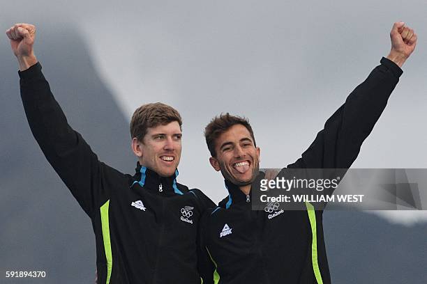 Gold medallists New Zealand's Peter Burling and New Zealand's Blair Tuke celebrate on the podium of the 49er Men medal race at Marina da Gloria...