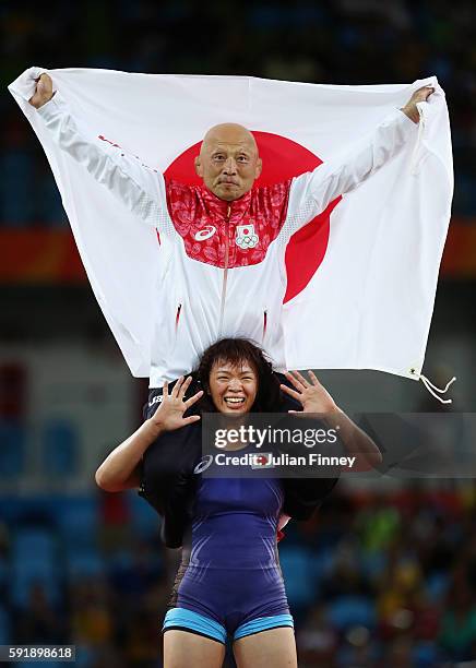 Risako Kawai of Japan celebrates with her coach Kazuhito Sakae after defeating Maryia Mamashuk of Belarus during the Women's Freestyle 63 kg Gold...