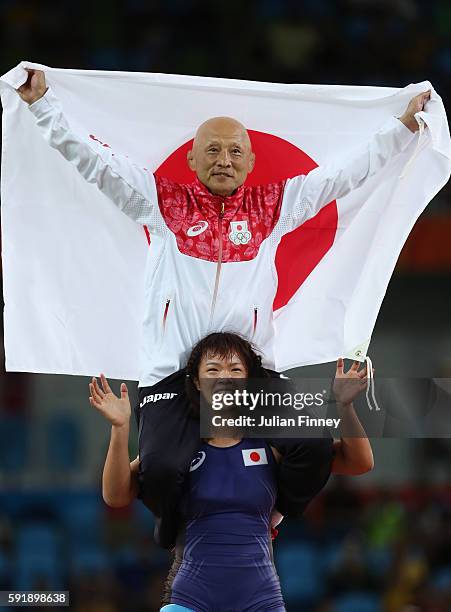 Risako Kawai of Japan celebrates with her coach Kazuhito Sakae after defeating Maryia Mamashuk of Belarus during the Women's Freestyle 63 kg Gold...