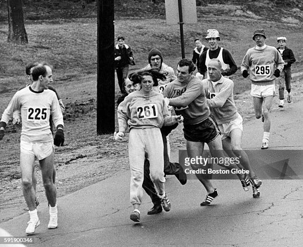 Kathrine Switzer, of Syracuse, N.Y., center, was spotted early in the Boston Marathon by Jock Semple, center right, who tried to rip the number off...