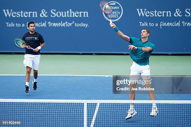 Max Mirnyi of Belarus hits a return as his doubles partner Treat Huey of the Philippines looks on during a third round doubles match against Rohan...