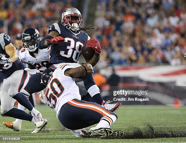 Brandon Bolden of the New England Patriots gains yards as Jerrell Freeman of the Chicago Bears defends in the first half during a preseason game with...