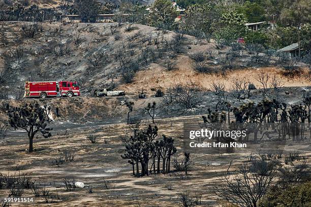 Beverly Hills Fire Engine 1 negotiates its way in Phelan against the backdrop of landscape charred by Blue Cut Fire.