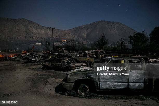 Burned vehicles sit in the glow of the full moon on Highway 138 as the Blue Cut fire continues to ravage San Bernardino County, Calif., on Aug. 18,...