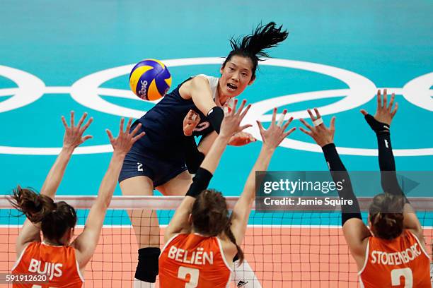 Ting Zhu of China strikes the ball at the Netherlands defence during the Women's Volleyball Semifinal match at the Maracanazinho on Day 13 of the...