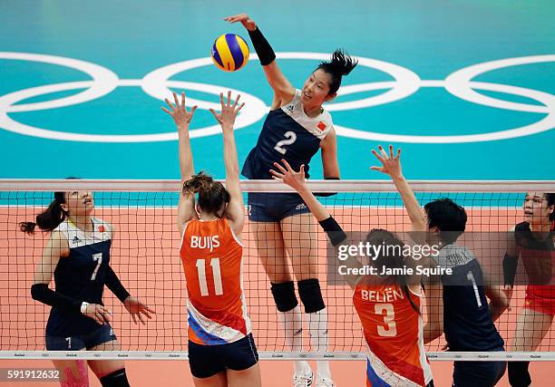 Ting Zhu of China strikes the ball at the Netherlands defence during the Women's Volleyball Semifinal match at the Maracanazinho on Day 13 of the...