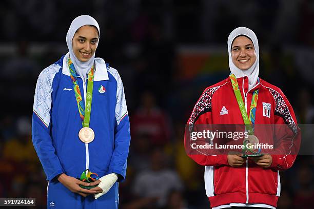 Bronze medalists, Kimia Alizadeh Zenoorin of the Islamic Republic of Iran and Hedaya Wahba of Egypt celebrate on the podium after the Women's -57kg...