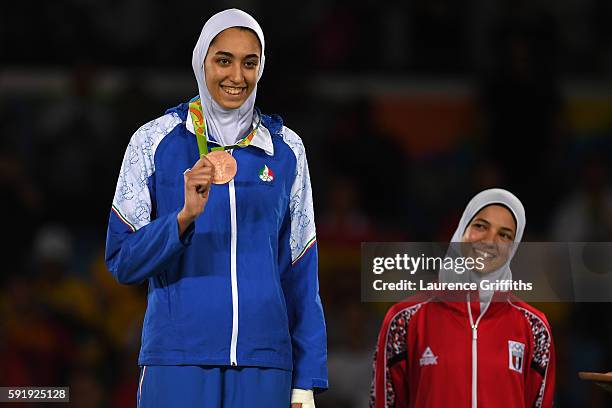 Bronze medalists, Kimia Alizadeh Zenoorin of the Islamic Republic of Iran and Hedaya Wahba of Egypt celebrate on the podium after the Women's -57kg...