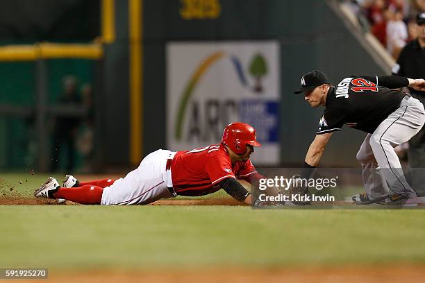 Chris Johnson of the Miami Marlins is unable to handle the throw as Ramon Cabrera of the Cincinnati Reds safely slides back into first after singling...