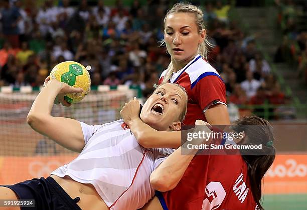 Heidi Loke of Norway is stopped by Ekaterina Ilina of Russia during the Women's Handball Semi-final match at the Future Arena on Day 13 of the 2016...