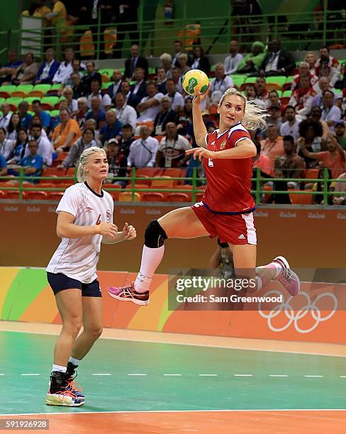 Polina Kuznetsova of Russia runs past Heidi Loke of Norway for a shot during the Women's Handball Semi-final match at the Future Arena on Day 13 of...
