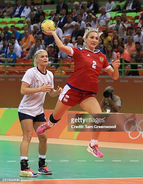 Polina Kuznetsova of Russia runs past Heidi Loke of Norway for a shot during the Women's Handball Semi-final match at the Future Arena on Day 13 of...