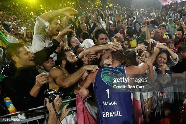 Alison Cerutti of Brazil celebrates with fans winning the Men's Beach Volleyball Gold medal match against Paolo Nicolai and Daniele Lupo of Italy at...