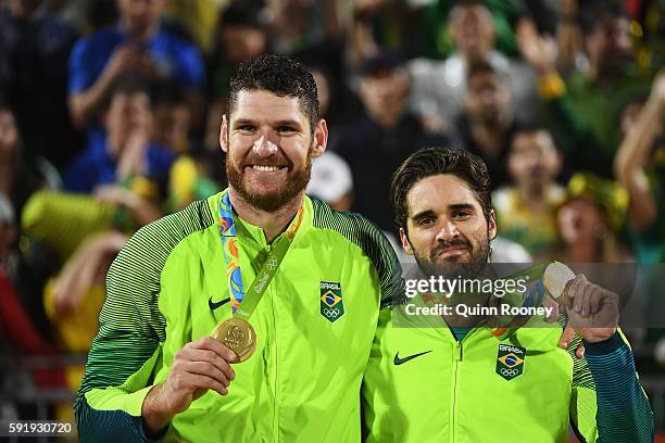 Gold medalists Alison Cerutti and Bruno Schmidt Oscar of Brazil stand on the podium during the medal ceremony for the Men's Beachvolleyball contest...