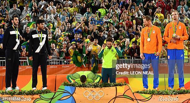 Brazil's gold medallists Alison Cerutti and Bruno Oscar Schmidt prepare to step on the podium at the end of the men's beach volleyball event at the...