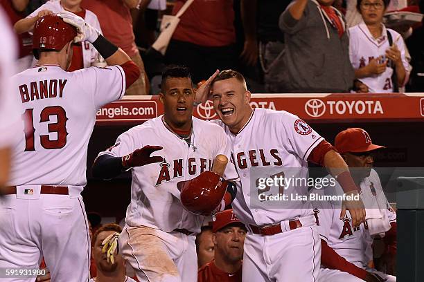 Jett Bandy celebrates with teammates Yunel Escobar and Mike Trout of the Los Angeles Angels of Anaheim after hitting a solo homerun in the fifth...