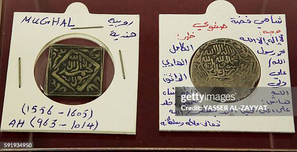General view shows an old Indian Rupee and Iranian Dirham, owned by renowned Kuwaiti coin collector Raed al-Ashi, displayed at the Kuwait national...