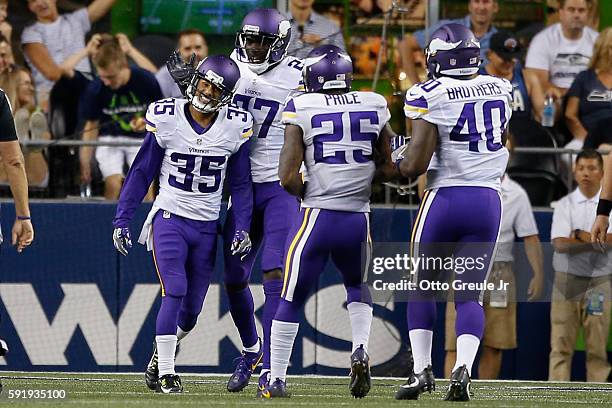 Cornerback Marcus Sherels of the Minnesota Vikings is congratulated by teammates after returning an interception for a touchdown against the Seattle...