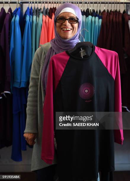 Australian-Lebanese designer Aheda Zanetti explains her products of burkini swimsuits at a shop in western Sydney on August 19, 2016. - Part bikini,...