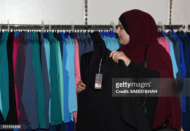 Muslim customer browses various burkini swimsuits at a shop in western Sydney on August 19, 2016. - Part bikini, part all-covering burqa, the burqini...