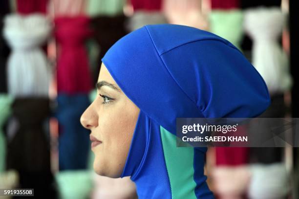 Muslim model display burkini swimsuits at a shop in western Sydney on August 19, 2016. - Part bikini, part all-covering burqa, the burqini swimsuit...