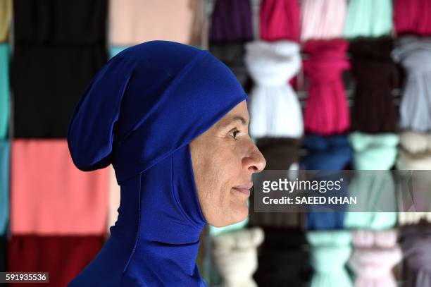 Muslim model displays burkini swimsuits at a shop in western Sydney on August 19, 2016. - Part bikini, part all-covering burqa, the burqini swimsuit...