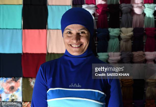 Muslim model displays burkini swimsuits at a shop in western Sydney on August 19, 2016. - Part bikini, part all-covering burqa, the burqini swimsuit...