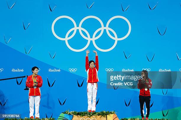 Silver medalist Si Yajie of China, gold medalist Ren Qian of China and bronze medalist Meaghan Benfeito of Canada celebrate on the podium during the...