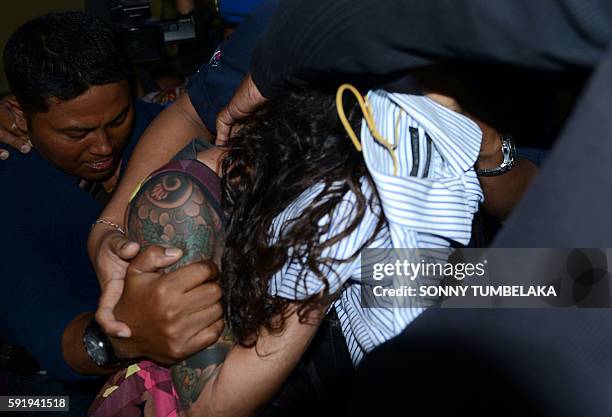 Sara Connor of Australia is escorted by Indonesia police officials at a station in Denpasar on Indonesia's resort island of Bali on August 19, 2016....