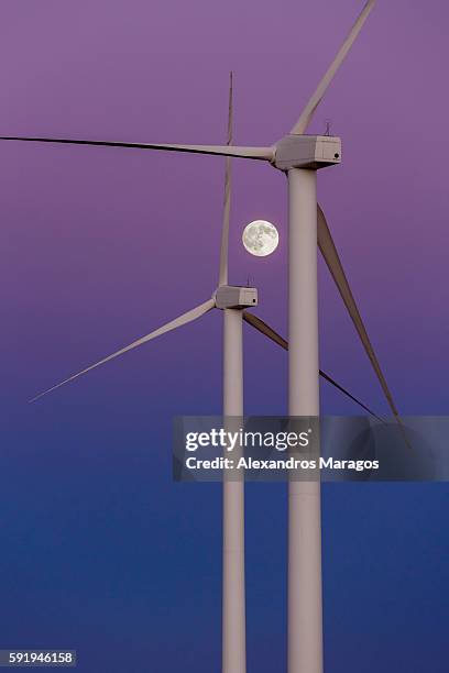 wind turbines and full moon at twilight. - alexandros maragos stock pictures, royalty-free photos & images