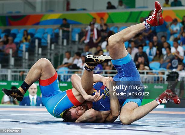 Kazakhstan's Galymzhan Usserbayev wrestles with Moldova's Evgheni Nedealco in their men's 74kg freestyle qualification match on August 19 during the...