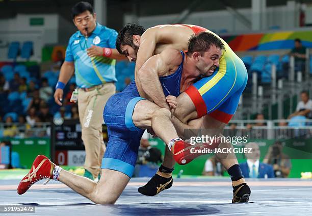 Kazakhstan's Galymzhan Usserbayev wrestles with Moldova's Evgheni Nedealco in their men's 74kg freestyle qualification match on August 19 during the...