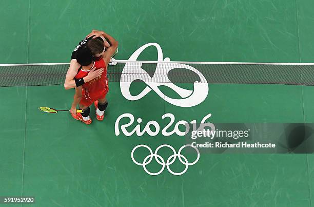 Long Chen of China embraces Viktor Axelsen of Denmark after winning the Men's Singles Badminton Semi-final on Day 14 of the Rio 2016 Olympic Games at...