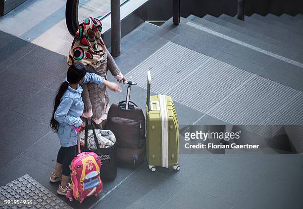 Traveler wait with their suitcases at the central station on August 19, 2016 in Berlin, Germany.
