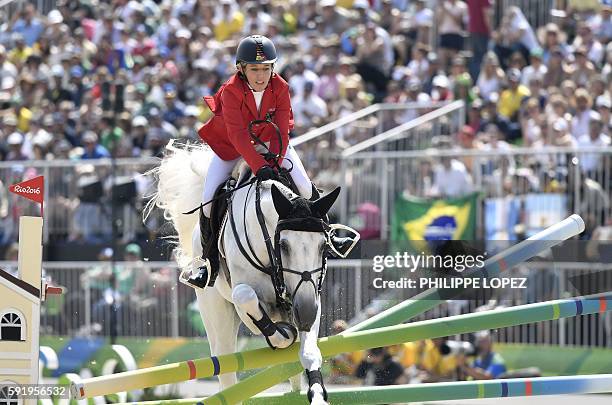 Germany's Meredith Michaels-Beerbaum on her horse Fibonacci crashes over an obstacle in the individual equestrian show jumping event at the Olympic...