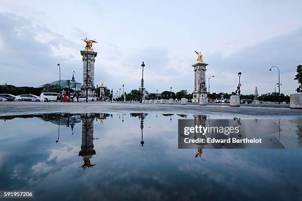 The bridge "Pont Alexandre iii " reflects into a water puddle on a rainy summer day, during the evening, on August 18, 2016 in Paris, France.