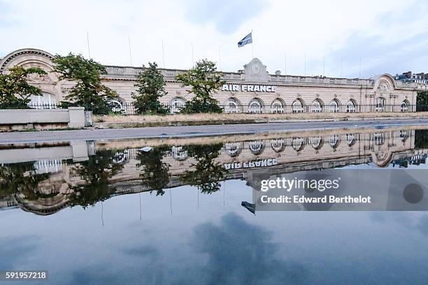 The Air France building reflects into a water puddle on a rainy summer day, during the evening, near the bridge "Pont Alexandre iii ", on August 18,...