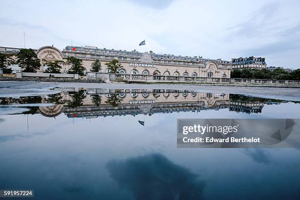 The Air France building reflects into a water puddle on a rainy summer day, during the evening, near the bridge "Pont Alexandre iii ", on August 18,...