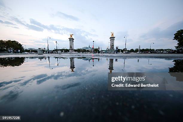 The bridge "Pont Alexandre iii " reflects into a water puddle on a rainy summer day, during the evening, on August 18, 2016 in Paris, France.