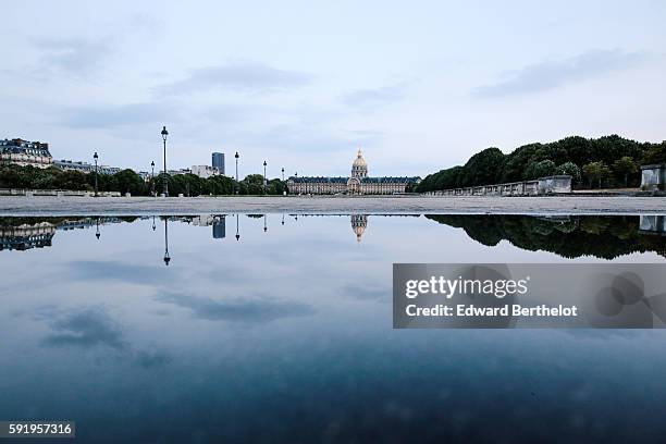 The Hotel des Invalides, reflects into a water puddle on a rainy summer day, during the evening, on August 18, 2016 in Paris, France.