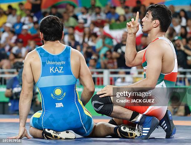 Iran's Hassan Aliazam Yazdanicharati celebrates after winning against Kazakhstan's Galymzhan Usserbayev in their men's 74kg freestyle semi-final...