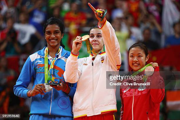 Silver medalist V. Sindhu Pusarla of India, gold medalist Carolina Marin of Spain and bronze medalist Nozomi Okuhara of Japan celebrate during the...