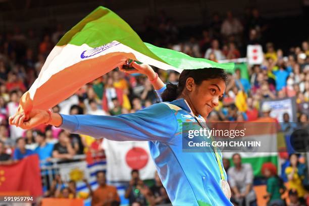 Silver medalist India's Pusarla V. Sindhu celebrates on the podium following the women's singles Gold Medal badminton match at the Riocentro stadium...