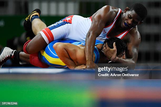 Liván López Azcuy of Cuba looks to turn Galymzhan Usserbayev of Kazakstan during men's freestyle wrestling on Thursday, August 19, 2016.